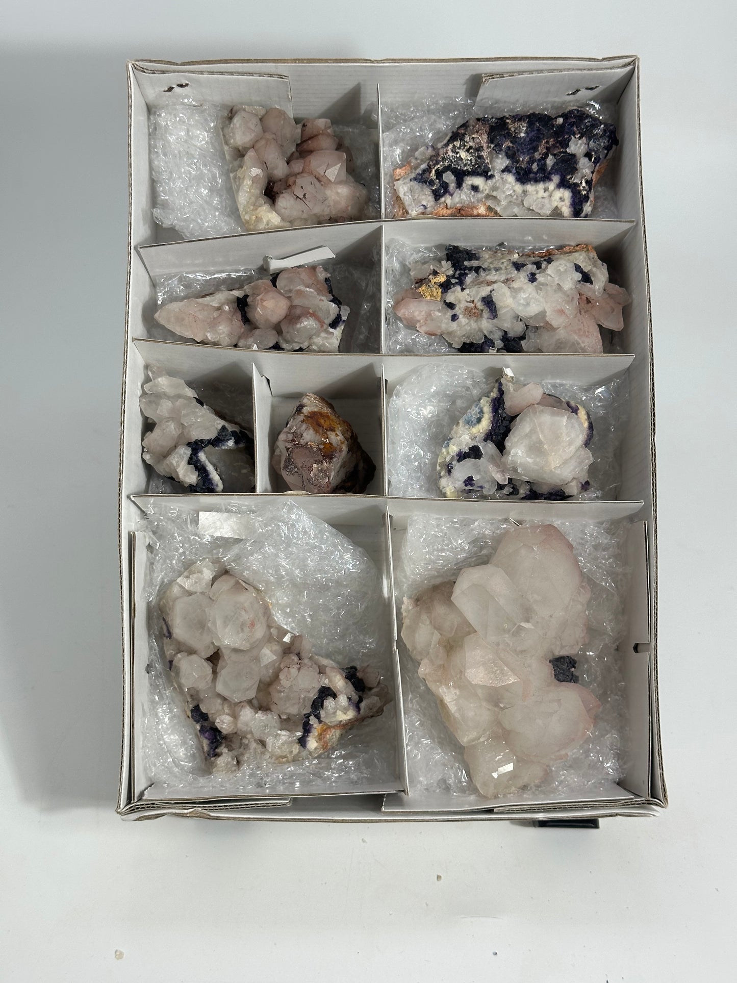 Box of various crystals and minerals on a white background