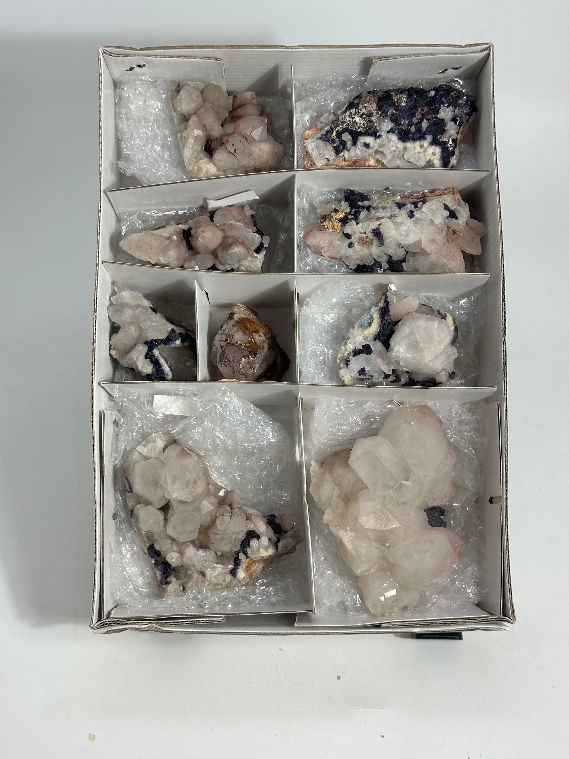 Box of various crystals and minerals on a white background