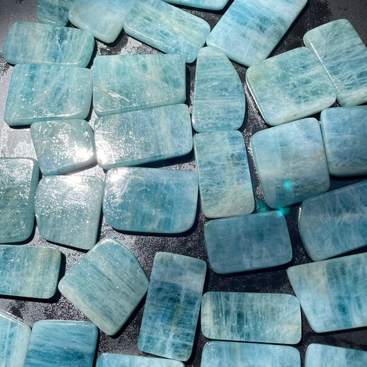 Collection of light blue rectangular stones on a dark surface